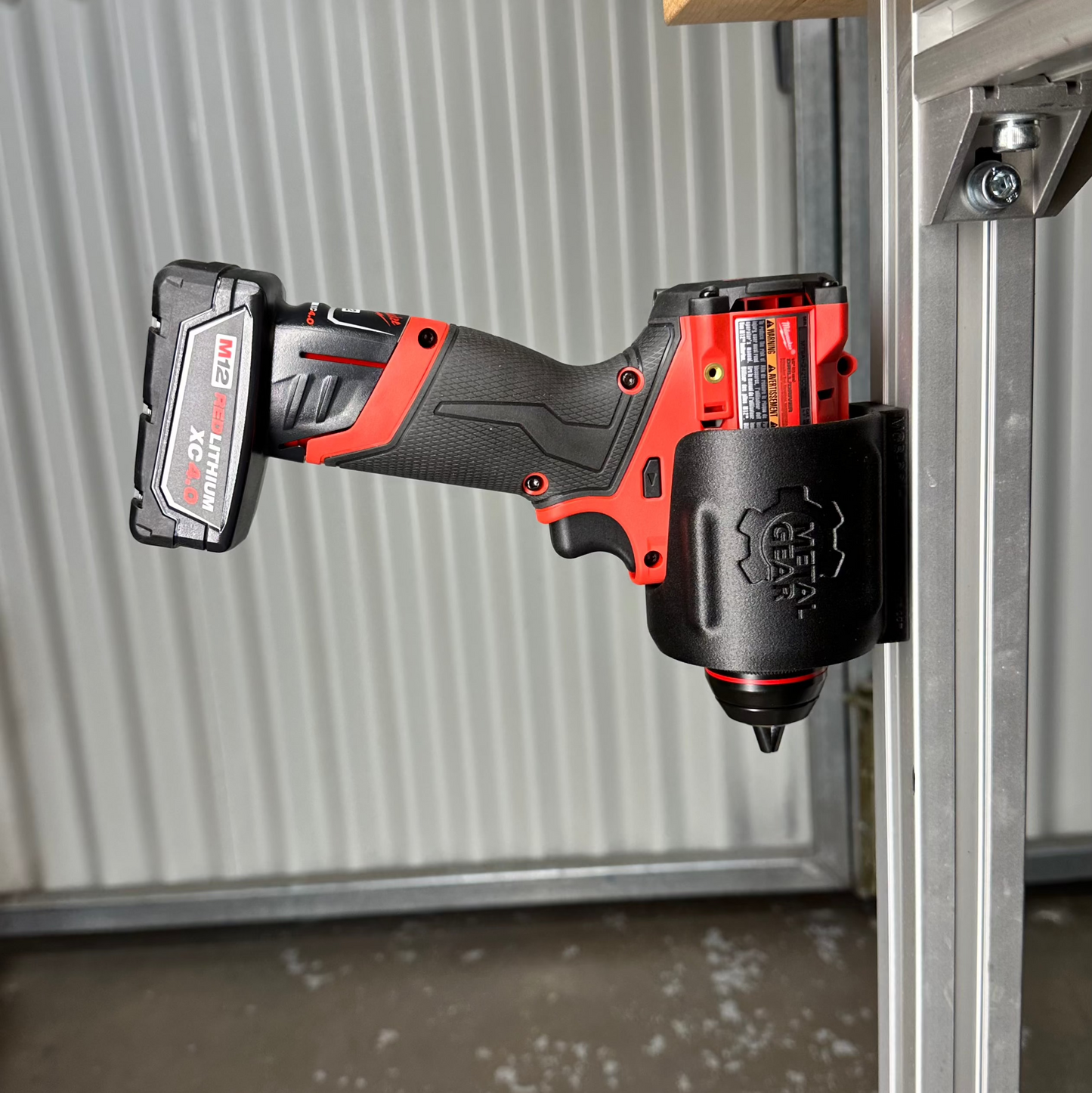 Milwaukee cordless power tool secured in the MGS-081 Holster by Metalgear Engineering—a rugged, 3D-printed tool holster designed for reliable mounting on walls, workbenches, or 80/20 framing in workshop and industrial environments.